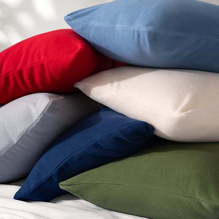 Stack of multicolored pillows on a bed