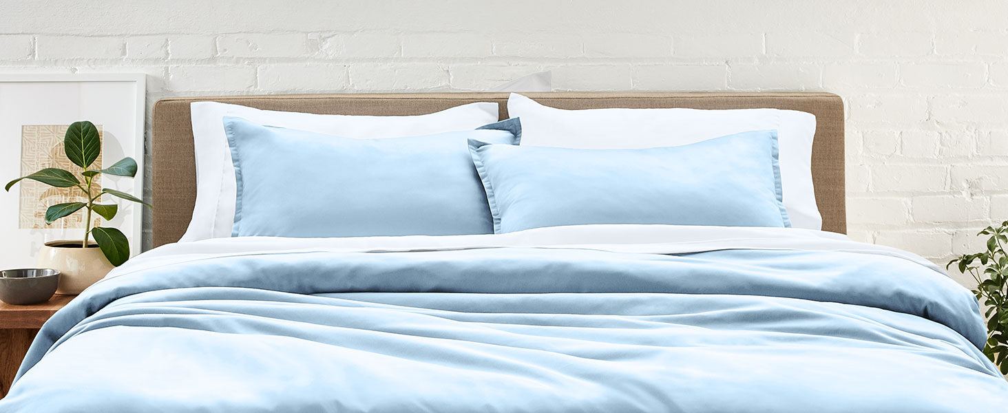 Light blue Pillow Sham and duvet on a well made bed