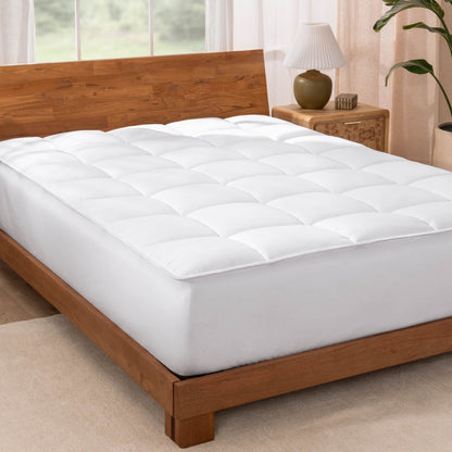 A reversible mattress pad on a bed with a wooden bed frame