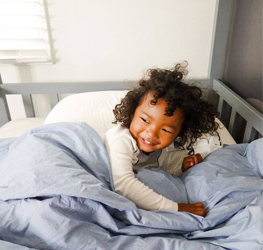 Person sleeping peacefully on a light blue-gray pillow