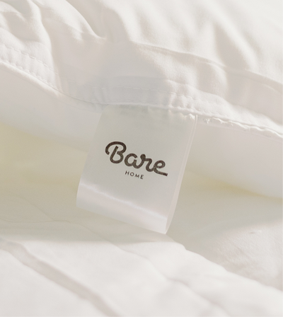 Close-up of a white pillow with a Bare Home branded tag