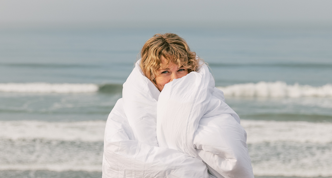 Girl wrapped in a white robe on the beach