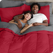 A couple is lying in bed with a comforter and sheets over them