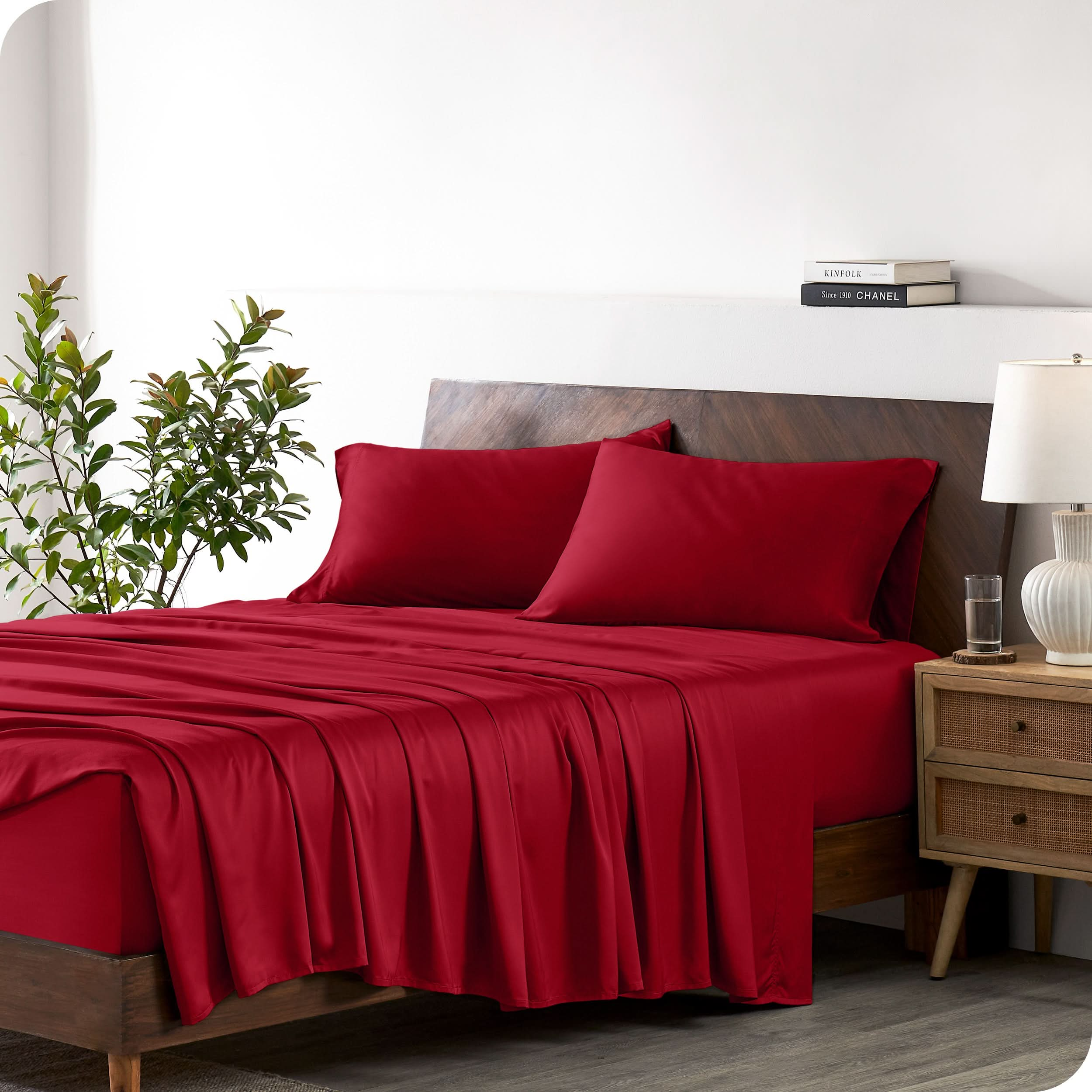 A bamboo sheet set draped over a bed with a wooden bed frame