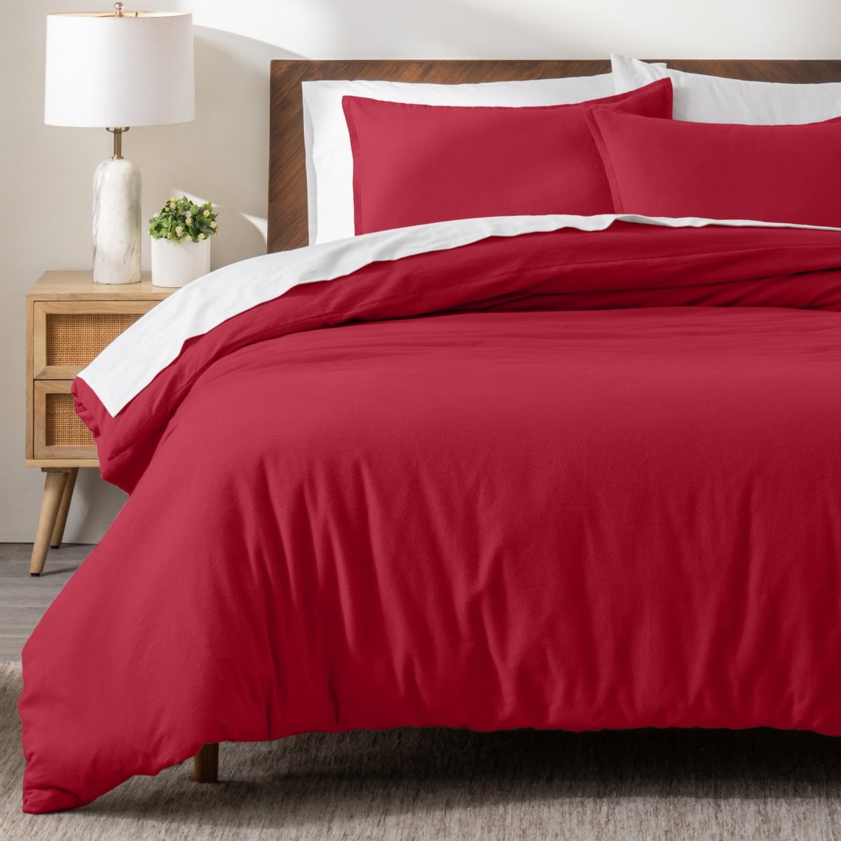 Flannel bedding set on a bed in a bedroom with a nightstand and lamp.