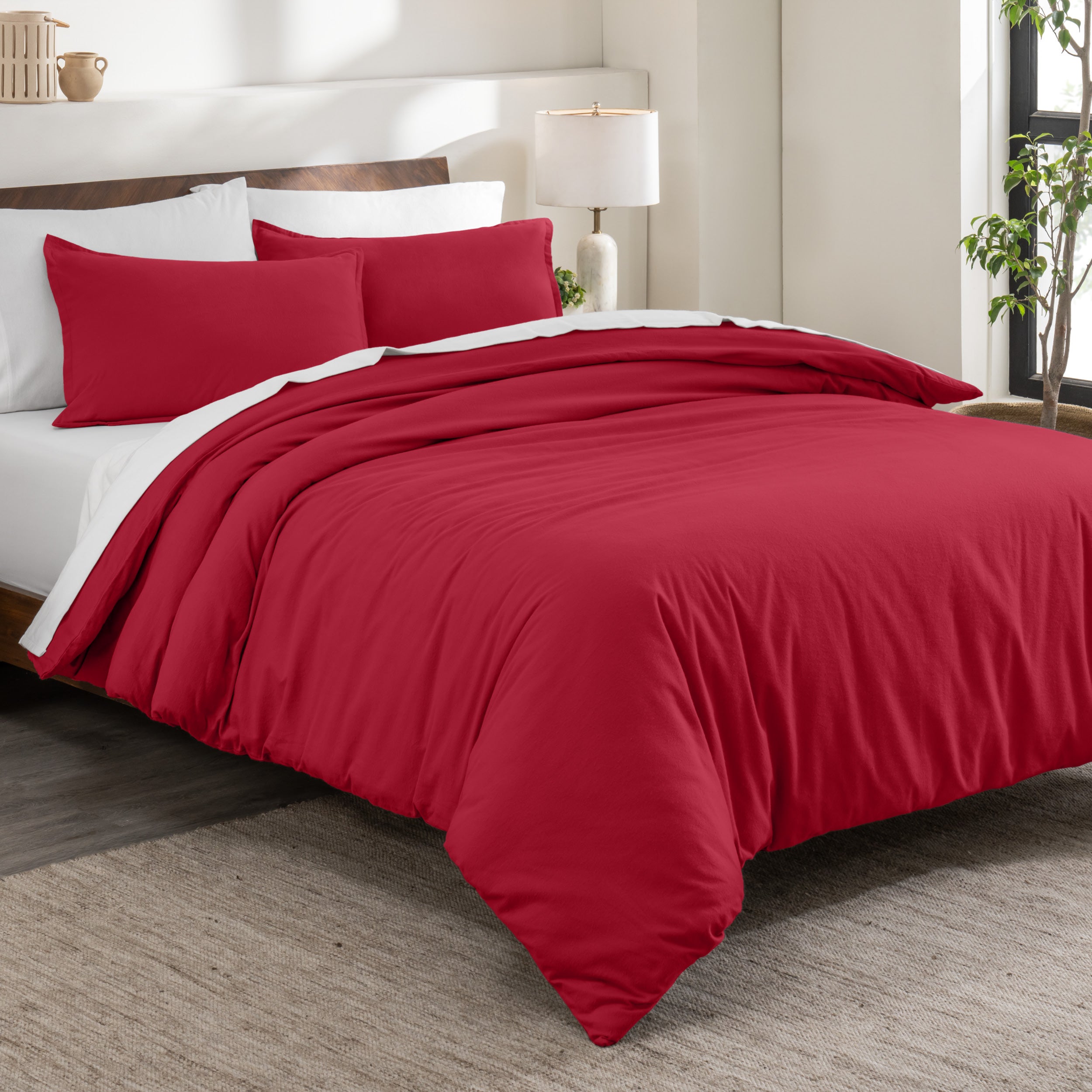 Flannel duvet cover set on a bed in a bedroom with a lamp and plant in the background.