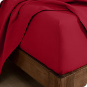 A close up of a corner of a modern bed with a flannel fitted sheet on.