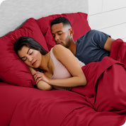 A couple sleeping with their heads resting on pillows with flannel pillowcases on them