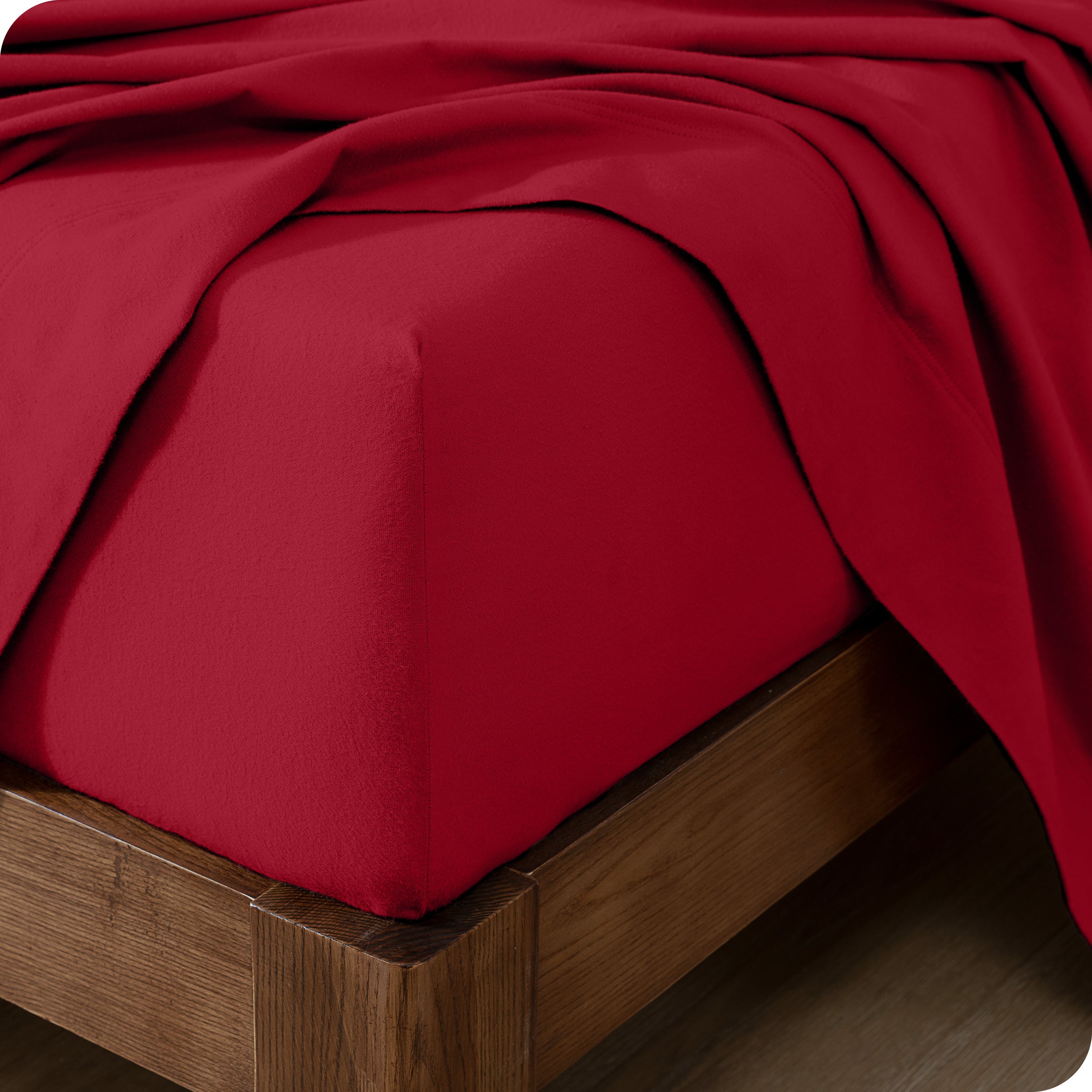 Close up of the corner of a mattress with a flannel fitted sheet and flat sheet on it