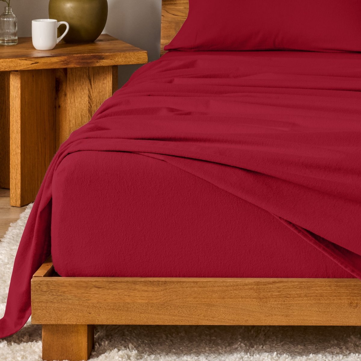 Bed with flannel bedding and wooden headboard and nightstand next to it.