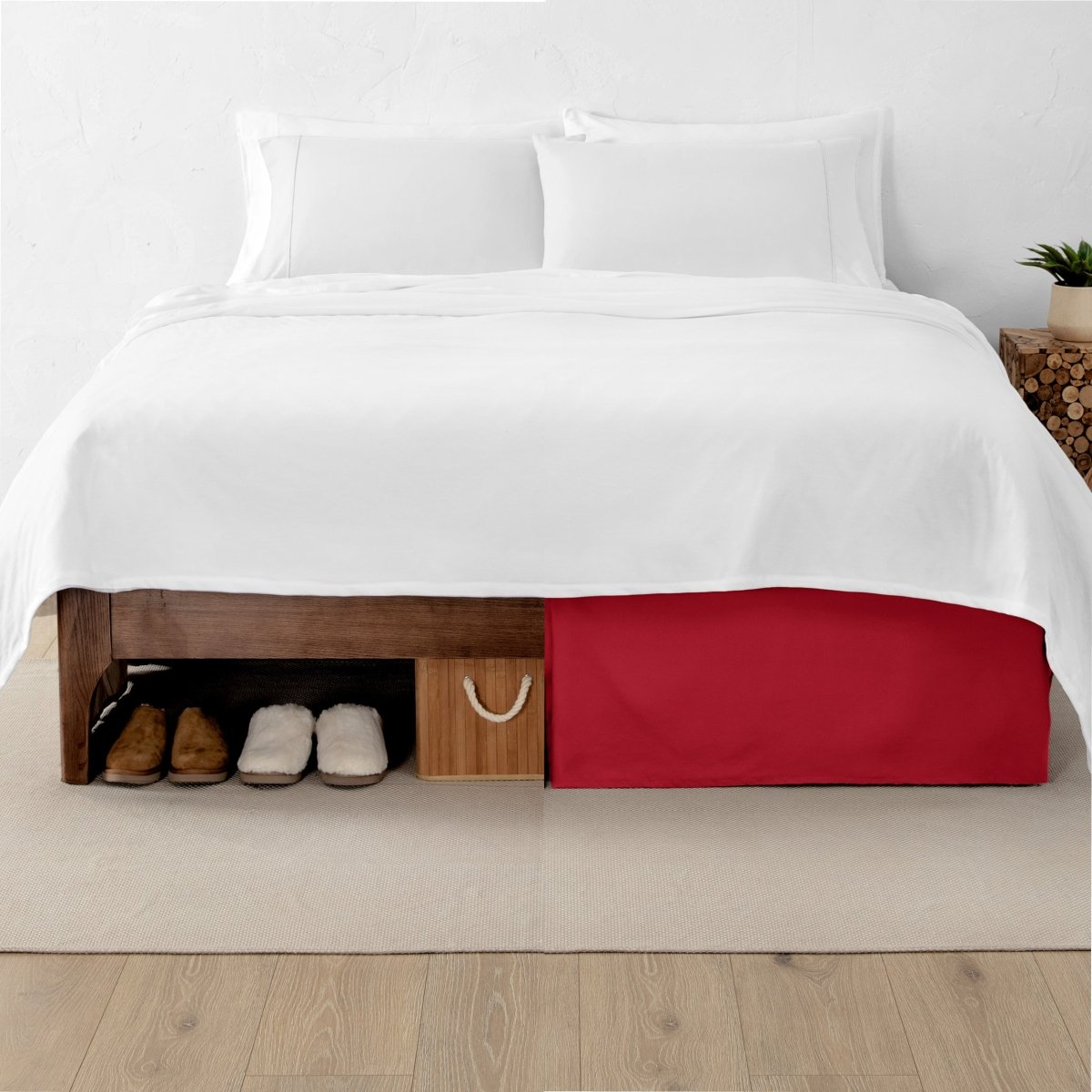 One side of a bed has shoes and a box under it while the other side has a bed skirt so that under the bed is hidden from view