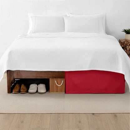 One side of a bed has shoes and a box under it while the other side has a bed skirt so that under the bed is hidden from view