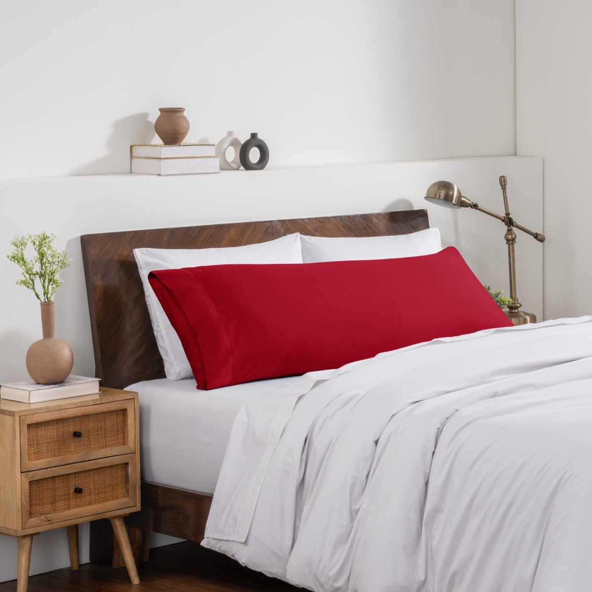 Bedroom with a wooden headboard and white bedding, featuring a nightstand and decorative items.