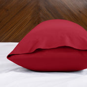 Body pillowcase with an envelope closure on a bed with a wooden headboard