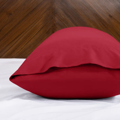 Body pillowcase with an envelope closure on a bed with a wooden headboard