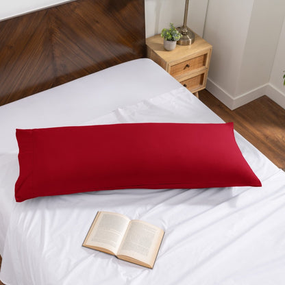 Pillowcase on a body pillow with a wooden headboard and plant in the background