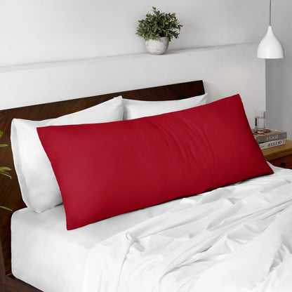 Body pillow on a bed with a wooden headboard and minimal decor.