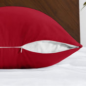 Body pillowcase with a zipper closure on a bed with a wooden headboard