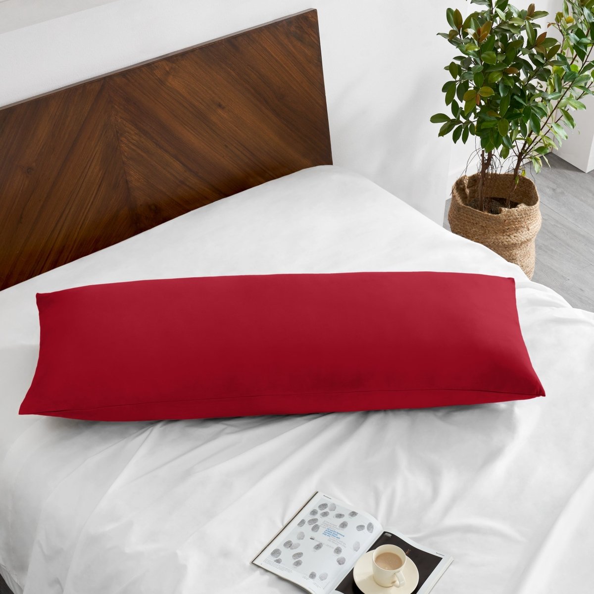 Pillowcase on a body pillow with a wooden headboard and plant in the background