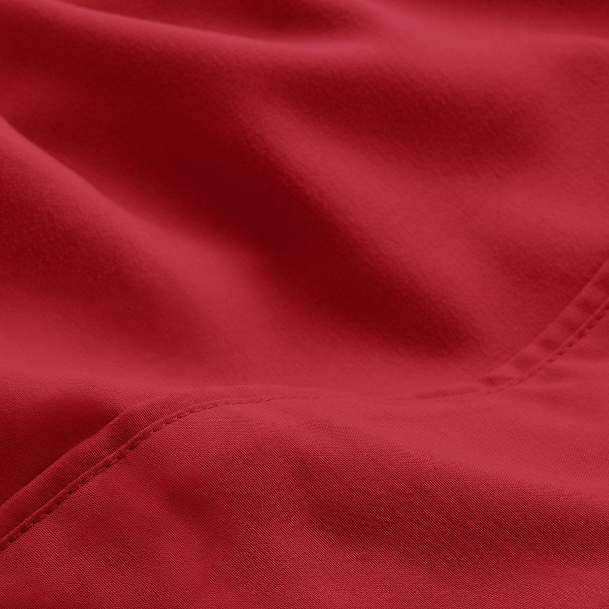 A close-up of microfiber fabric with soft folds and a visible stitched seam.