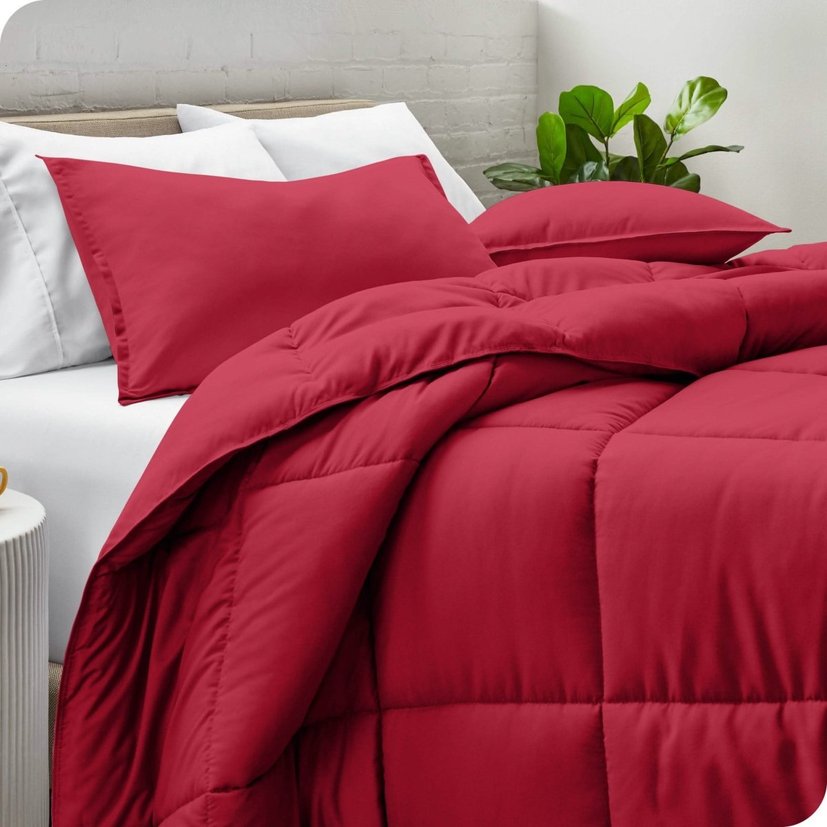 A side view of a modern bed with a comforter set and pillows on the bed