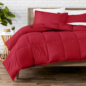 Comforter set on a bed with a white brick wall and plant in the background