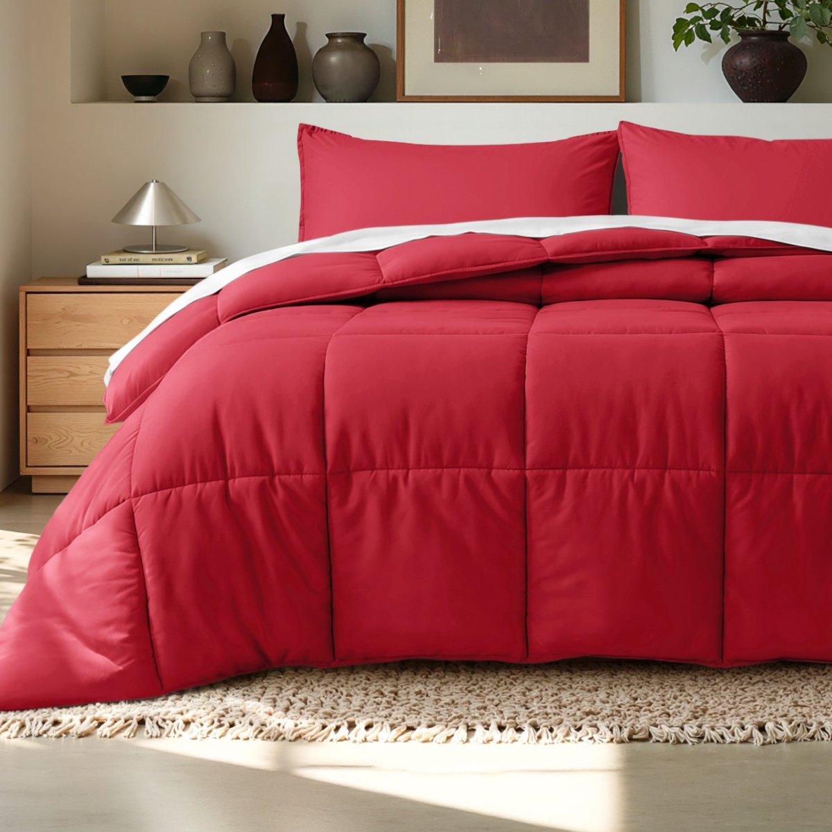 Comforter on a bed in a bedroom setting with a wooden nightstand and decorative items.