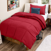 Bed with comforter and pillows in a dorm room