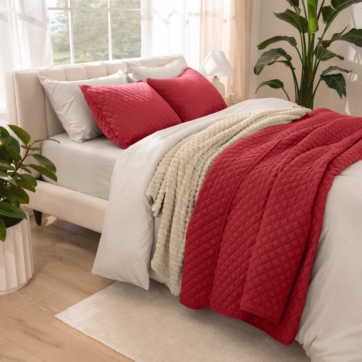 Side view of bed with coverlet set draped on a bed made with a duvet set