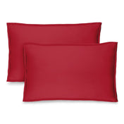 Two red pillow shams on pillows standing up with one behind the other