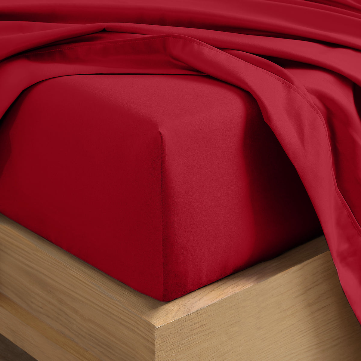 Close up of the corner of a mattress with a fitted sheet and flat sheet on it