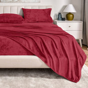 Microplush sheet set on a bed in a bedroom setting with a nightstand and lamp.