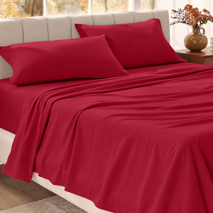 Bed sheets on a neatly made bed in a bright bedroom with large windows.