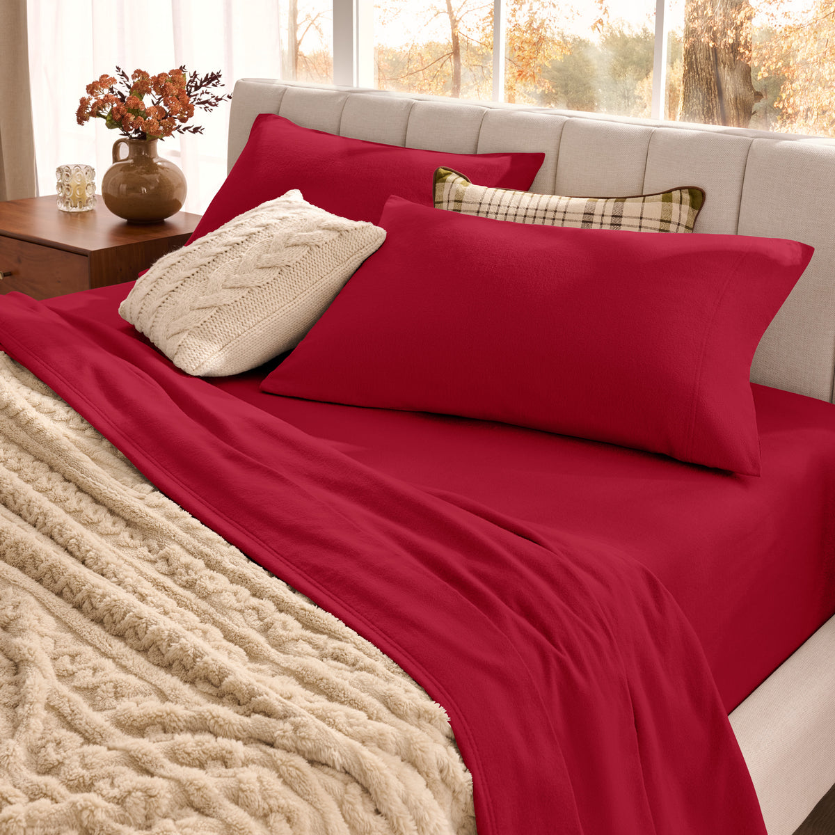 Neatly made bed with organic flannel sheets  and a beige blanket in a bright bedroom.