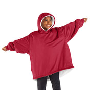 A boy standing with his arms stretched out while wearing a wearable blanket