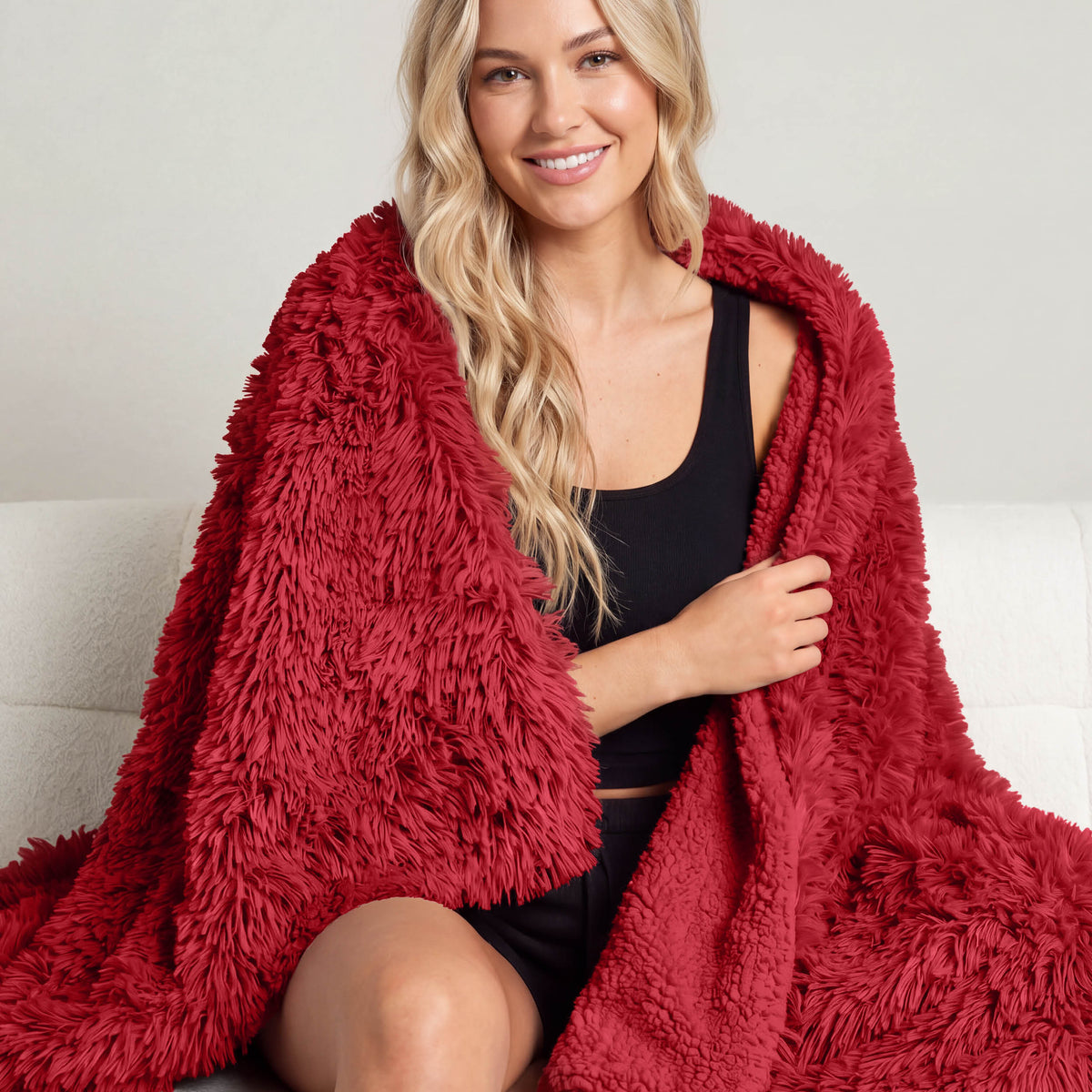 A woman sitting with a shaggy blanket wrapped around her