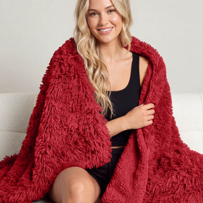 A woman sitting with a shaggy blanket wrapped around her