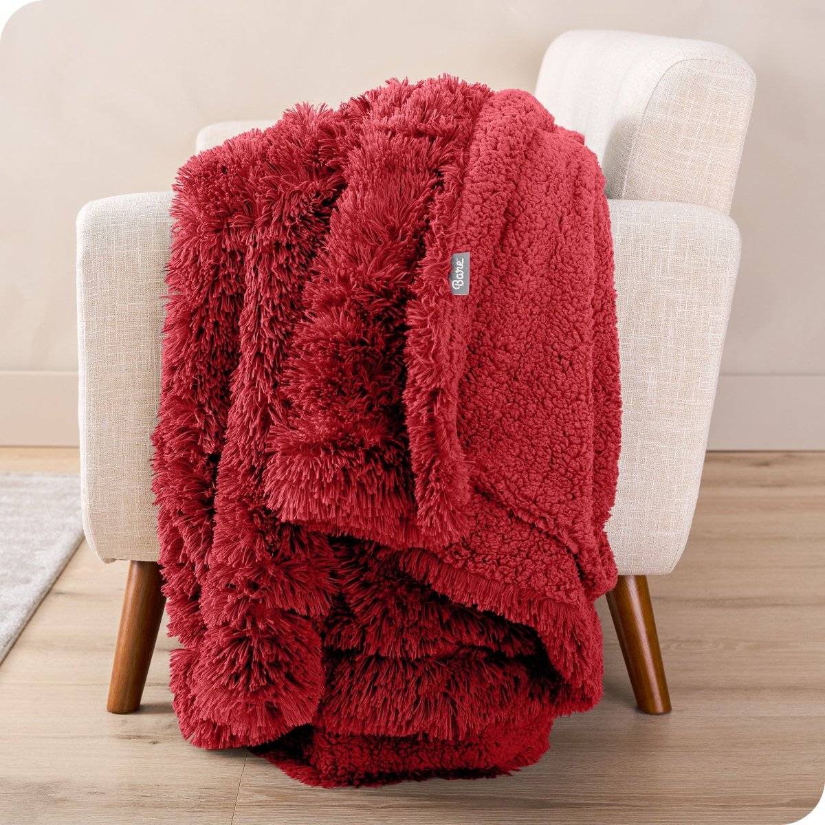 A shaggy faux fur blanket draped over the arm of a chair