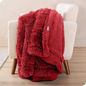 A shaggy faux fur blanket draped over the arm of a chair