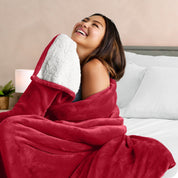A woman smiling while wrapped in a sherpa blanket