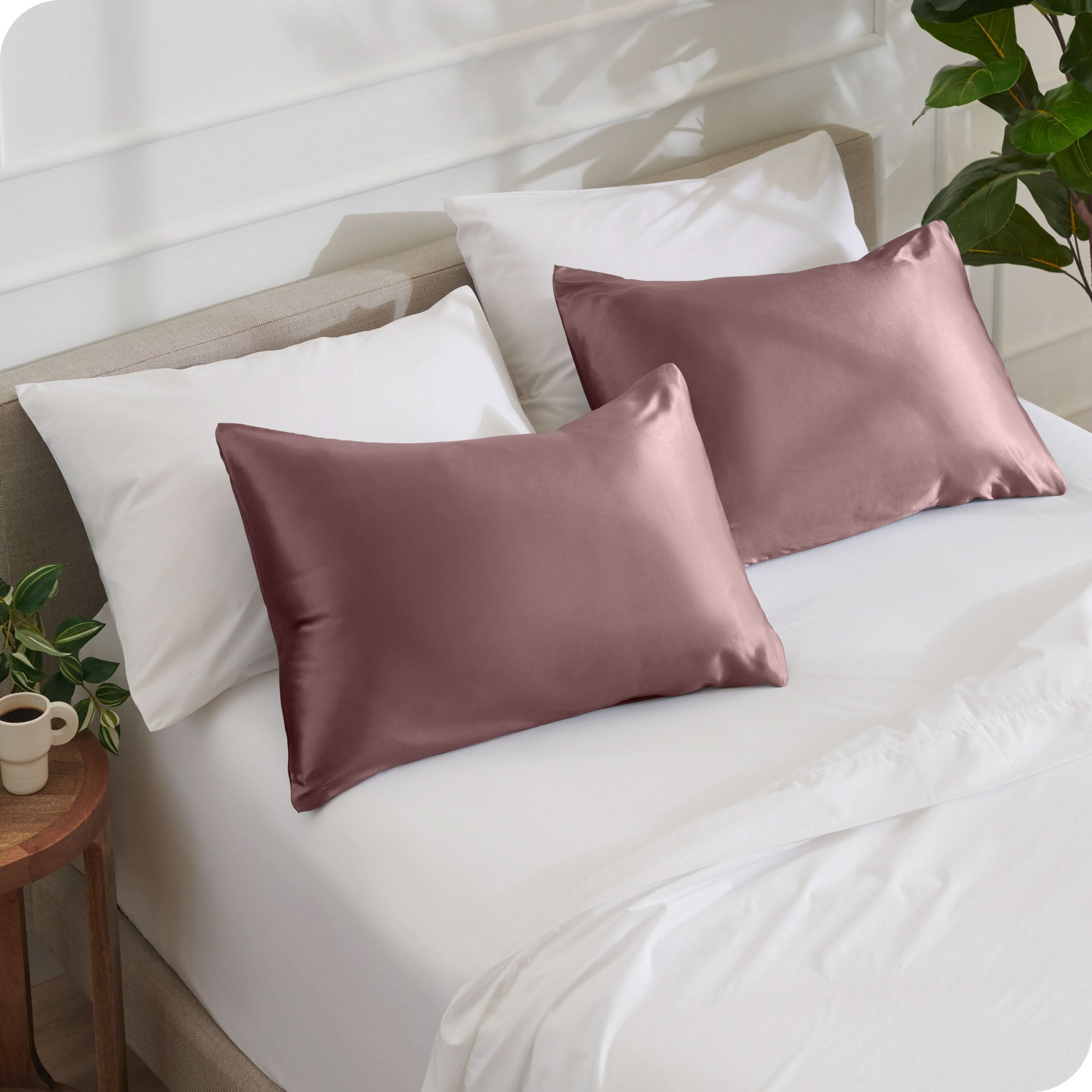 2 satin pillowcases on pillows set on a bed