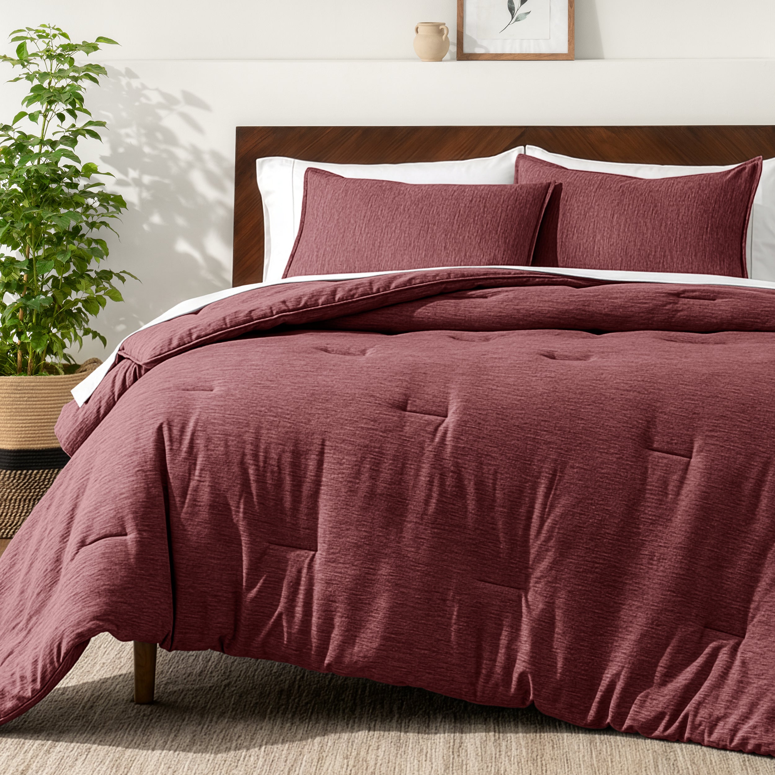 Bedding set on a bed in a bedroom with a side table and lamp.
