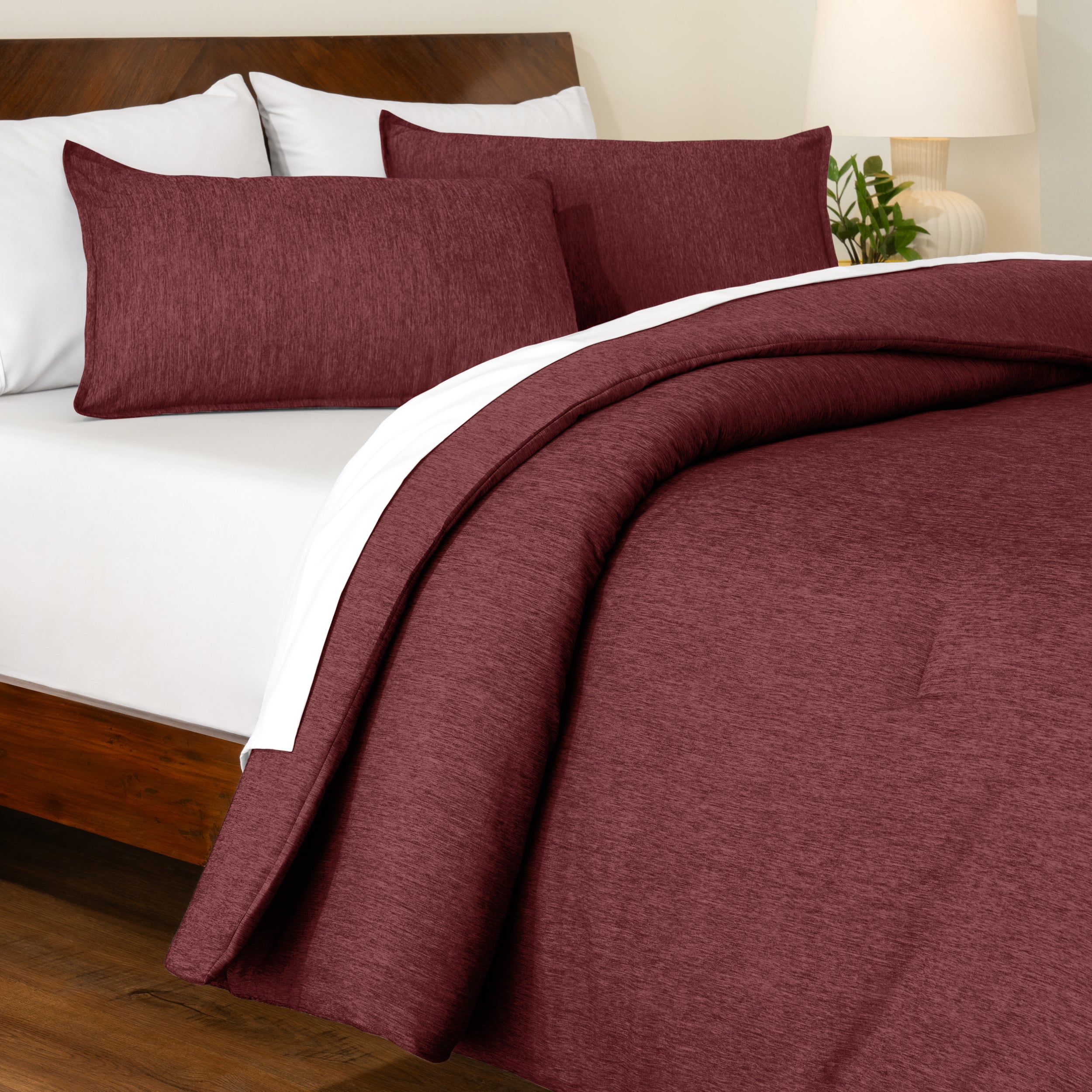 Track stitch comforter on a bed with white pillows and a wooden headboard.