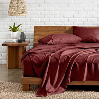 Bedroom with wooden bed, nightstand, and white brick wall.