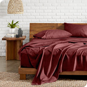 Bed with microfiber bedding against a white brick wall.