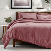 A bedroom with a side table, decor and a neatly made bed