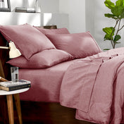 Bedding set on a bed in a bedroom with a side table and lamp.