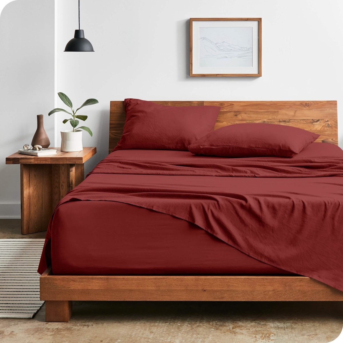 Modern bedroom with washed sheets draped over the end and the side of the bed