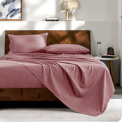 View from the end of a bed with matching sheets and pillowcases.