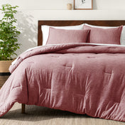 Bedding set on a bed in a bedroom with a side table and lamp.